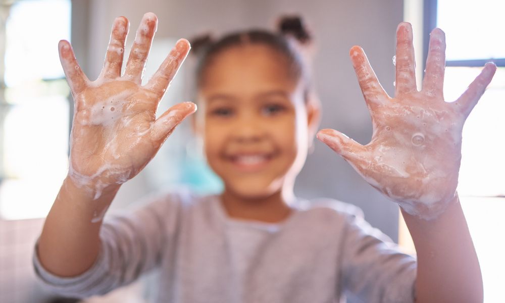 child with soap on their hands